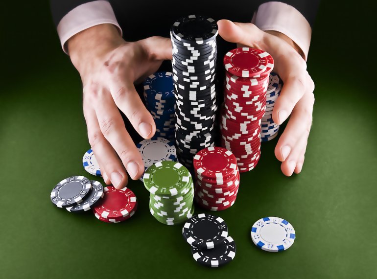 Hands stretch to a pile of chips
