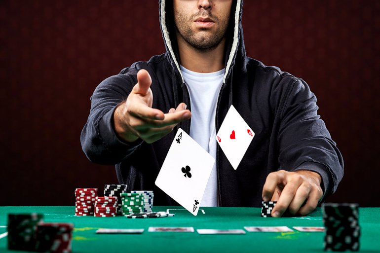 The man at the gaming table throws two aces