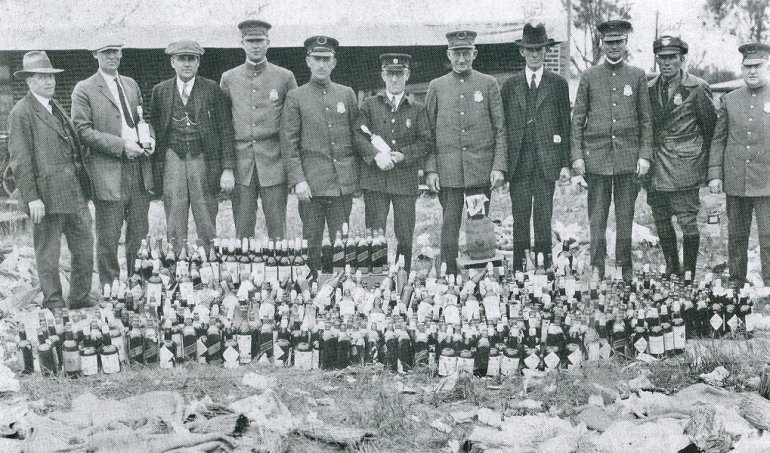 Police officers with confiscated illegal alcohol