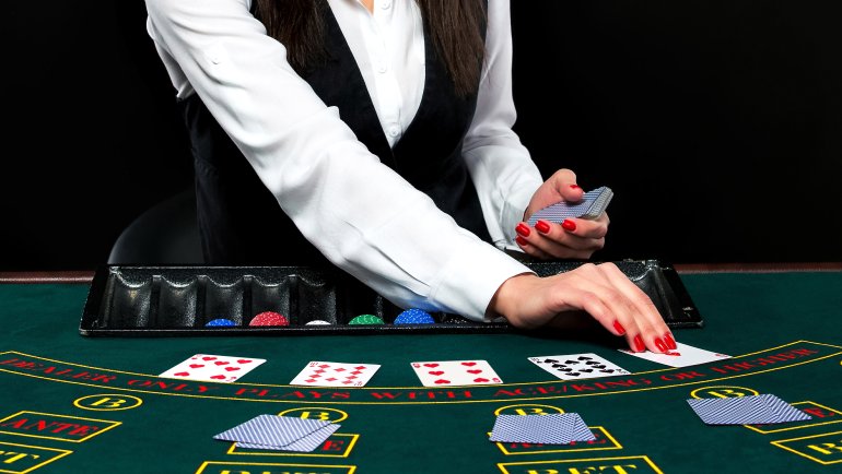 Lady dealer deals blackjack game