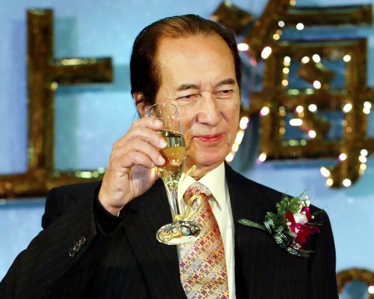 Gambling magnate Stanley Ho with a glass of champagne in his hands